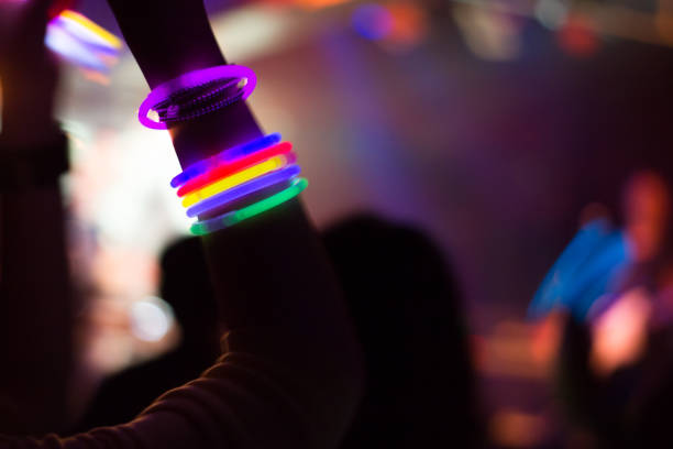 Nightclub, Silhouette of People Having Fun Rear view of people enjoying music concert at a nightclub.
 glow stick stock pictures, royalty-free photos & images