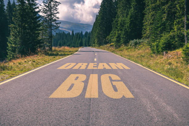 istock Asphalt road in the mountains going straight up with dream big text message. Conceptual business motivation background. 903650536