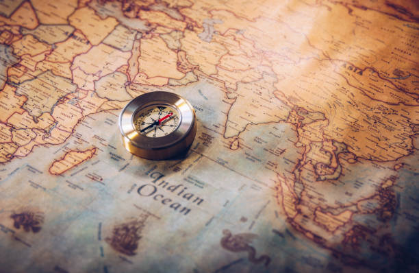 istock Old compass on vintage map. Adventure stories background. Retro style. The map used for background is in Public domain. Map source: Library of Congress. Country: Belgium Year: 1570. Author: Abraham Ortelius (1527-1598) 903650636