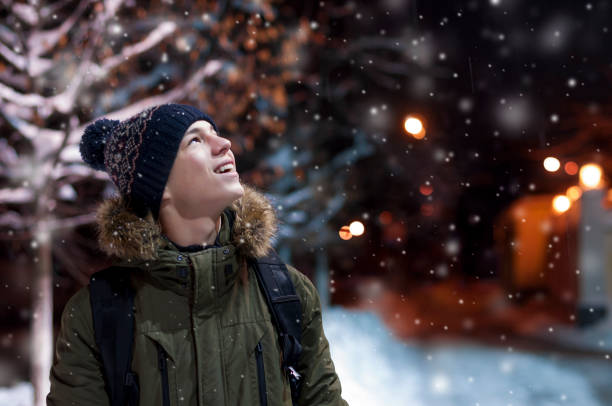 istock happy young man on a city street during a snowfall 903658902