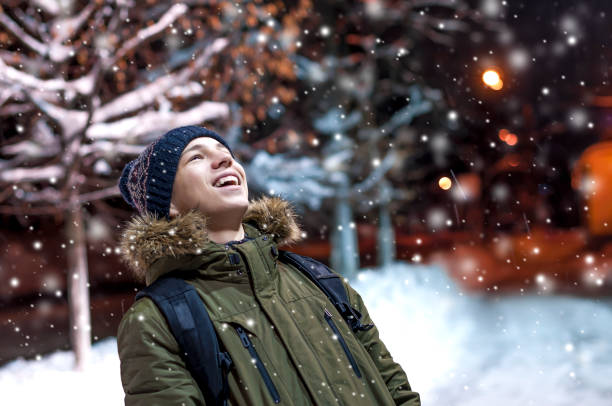 istock happy young man on a city street during a snowfall 903659038