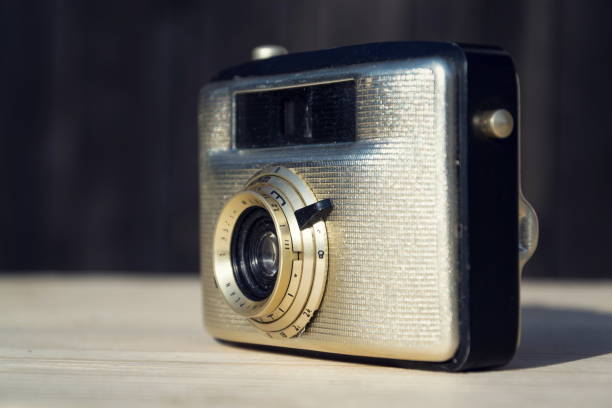 istock Old vintage golden camera on wooden background 903659132