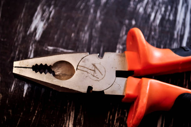 istock Pliers for repair work lying on the table. Repair tools in the h 903659144