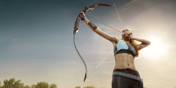 istock Female archer shooting with the longbow at sunset 903659278