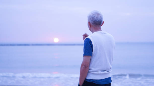 istock Asian senior man standing alone at sunrise morning 903659482