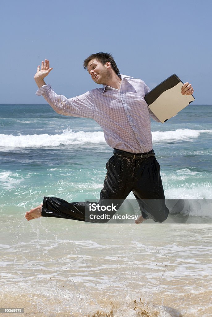 Salto de hombre con una computadora portátil - Foto de stock de 20 a 29 años libre de derechos