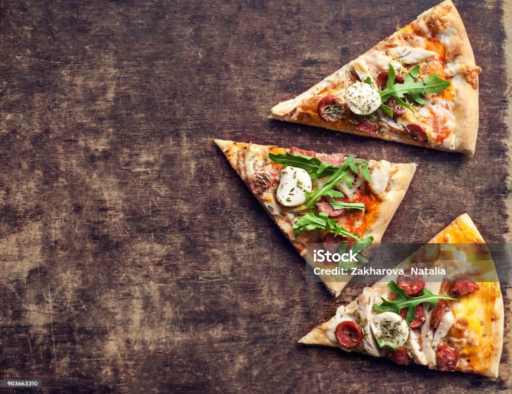 Hot Italian pizza with melted mozzarella cheese and tomato on a rustic wooden table.  Pizza Ready to Eat, Copyspace."n Baked Stock Photo