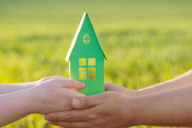 istock paper house in hand outdoor 903666678