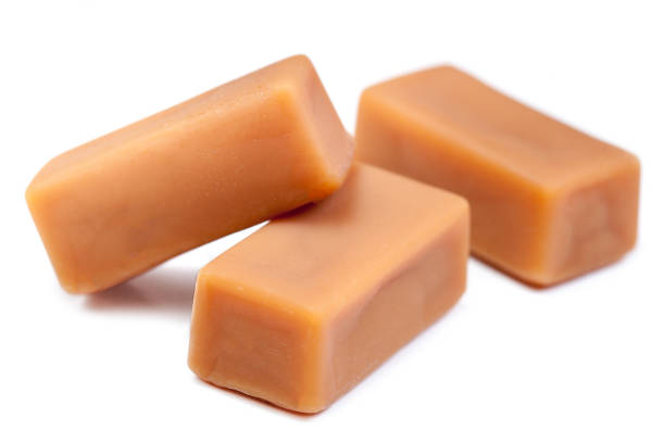 istock Delicious caramel candies chunks  isolated on white background  with copy space, macro. 903671506