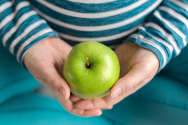 istock Pregnant woman holding green apple 903678730