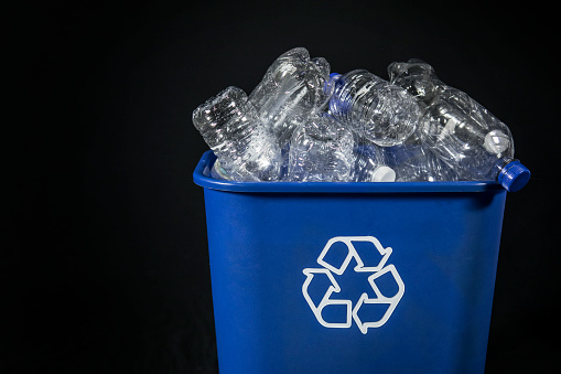 A recycling bin full of empty plastic water bottles.
