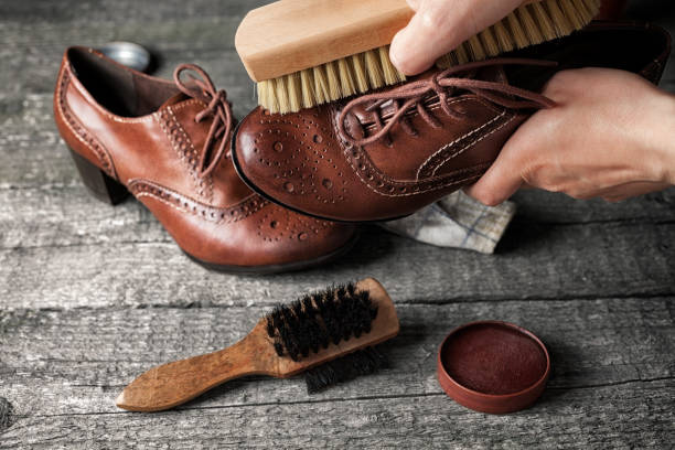 Worker cleaning shoe with brush Worker cleaning shoe with brush in his workshop leather care stock pictures, royalty-free photos & images