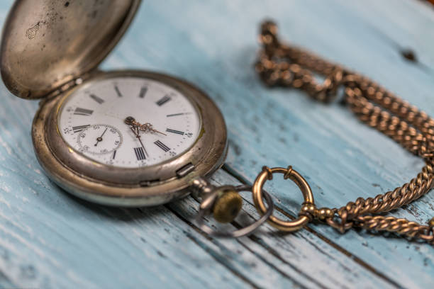 istock Silver vintage pocket watch on wooden table 903685794