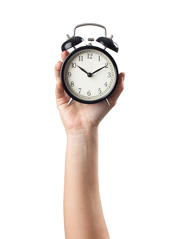 Woman's hand on a white background isolated with an alarm clock