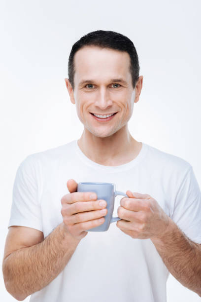 istock Cheerful positive man holding a cup of tea 903686126