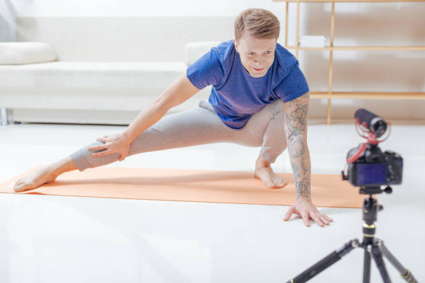 istock Attentive blogger looking straight to the camera while recording a yoga lesson 903686156