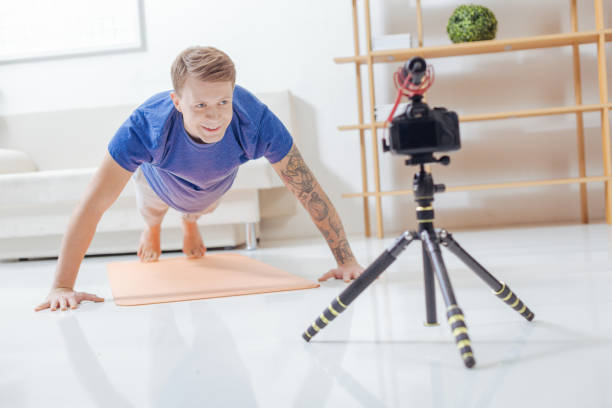 istock Handsome man doing pushups while recording his video blog 903686294