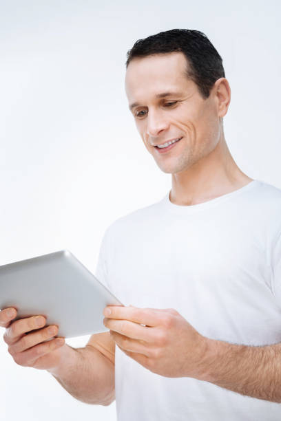 istock Happy cheerful man looking at the tablet screen 903686372