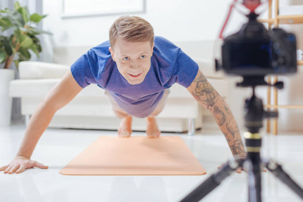 istock Healthy blogger smiling while doing pushups at home 903686542