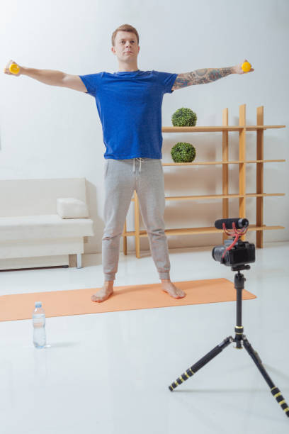 istock Concentrated man standing on the mat and holding hand weights 903687748