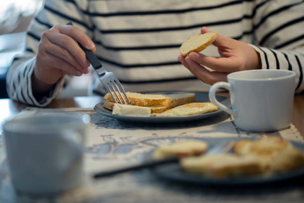 istock girl eating toast bread and drinking coffee at breakfast 903694588