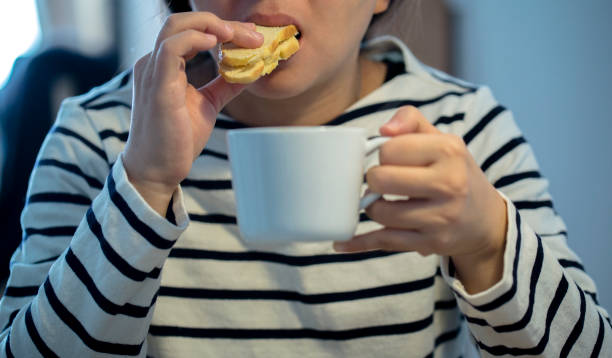 istock girl eating toast bread and drinking coffee at breakfast 903694848
