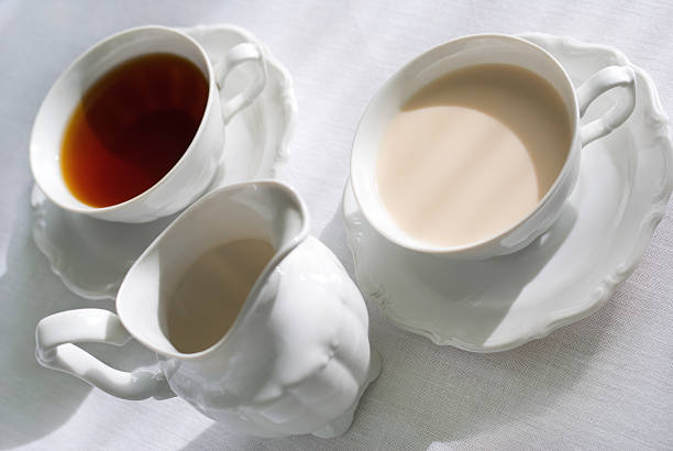 dos tazas de té y jarra de leche. - nobody tablecloth cup saucer fotografías e imágenes de stock