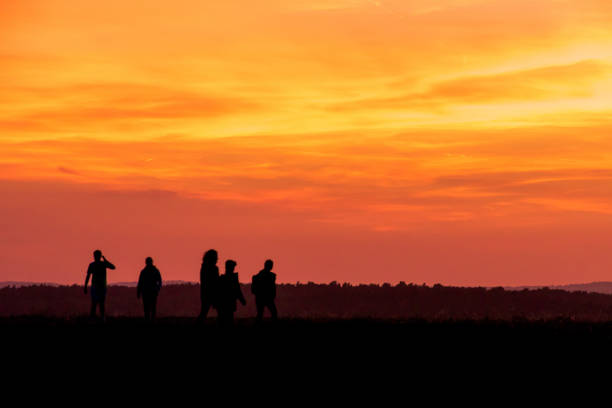 istock Silhouette People Walking On Landscape Against Orange Sky 903696780
