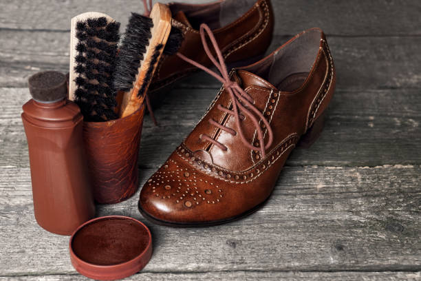 istock Shoe wax and brushes on wooden surface 903696914