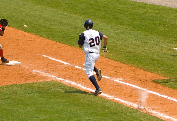 jugador de béisbol corriendo a la primera béisbol durante el partido de béisbol - baseball diamond baseball baseline grass fotografías e imágenes de stock