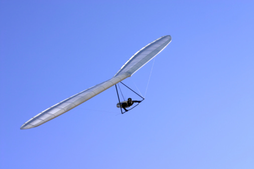 Hang glider flying through the clear blue.