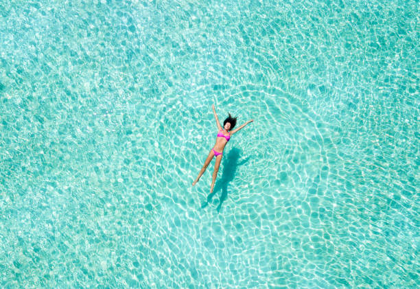 istock Woman floating on tropical waters 903699632