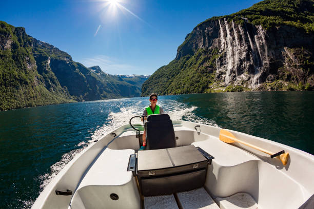 Woman driving a motor boat. Geiranger fjord, Beautiful Nature Norway. Summer vacation.