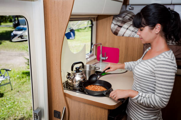 istock Woman cooking in camper, motorhome RV interior 903702476