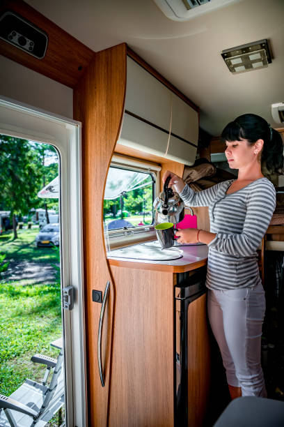 istock Woman cooking in camper, motorhome interior RV 903702500