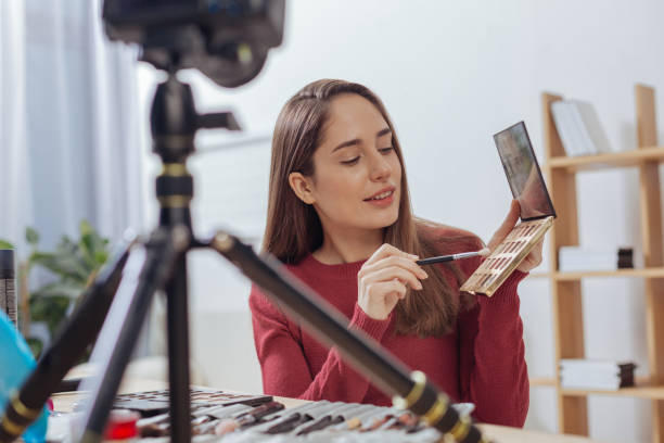 istock Young attentive woman sitting at the table with a shadow palette 903702874