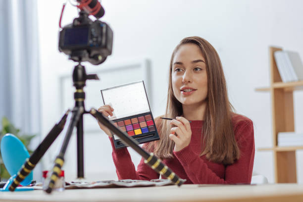 istock Experienced blogger looking at the camera while showing shadow palette 903703618