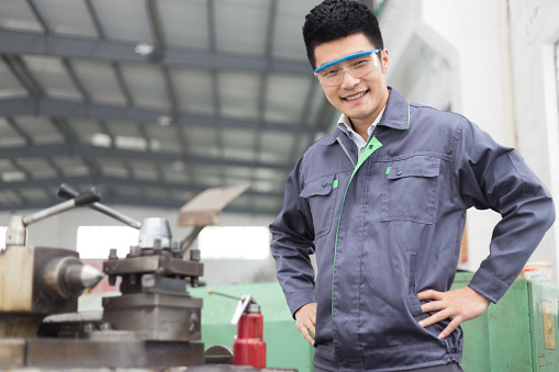 young chinese man works in motor manufacturing factory