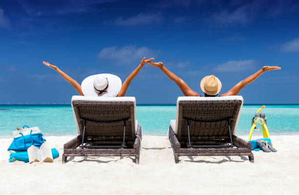 istock Happy couple in sunbeds on a tropical beach 903707670