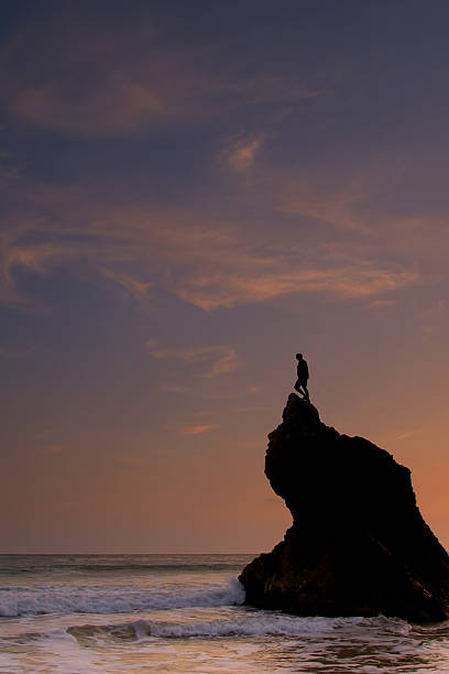 silhouetted man standing on top of ocean sunset rock formation  rock sea malibu silhouette stock pictures, royalty-free photos & images