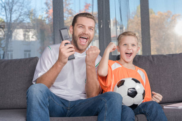 istock father and son watching soccer match 903712656