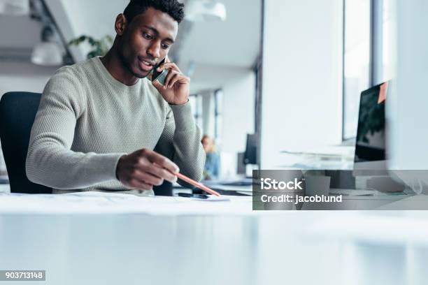 Photo libre de droit de Architecte De Mâle Africain Travaillant Au Cabinet banque d'images et plus d'images libres de droit de Hommes - Hommes, Utiliser un téléphone, Couleur noire