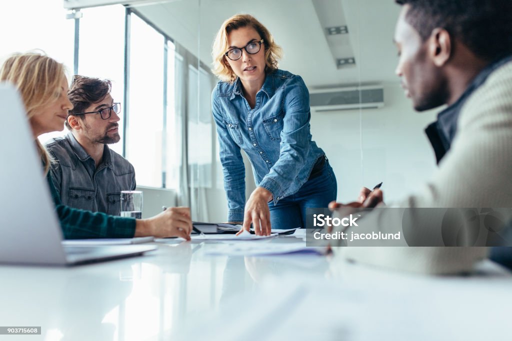 Businesswoman leading business presentation Businesswoman standing and leading business presentation. Female executive putting her ideas during presentation in conference room. Leadership Stock Photo