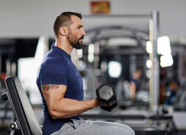 istock Man doing biceps curl in the gym 903719750