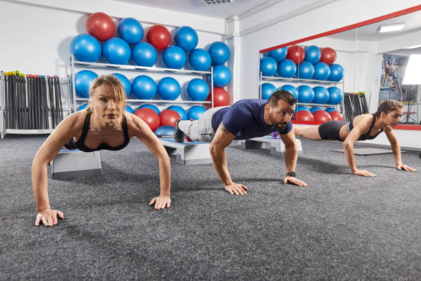 istock Fitness trainer and girls doing pushups 903722826