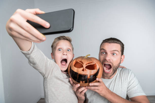istock father and son with halloween pumpkin 903722968