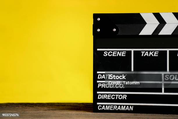 Movie Clapper On Wood Table With Yellow Background Film Cinema And Video Photography Concept Stock Photo - Download Image Now