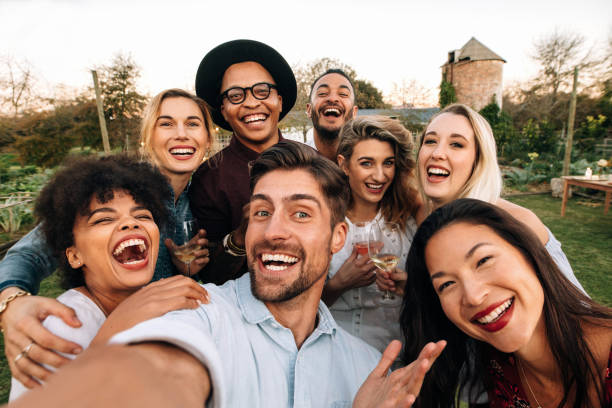 Friends making a selfie together at party Friends chilling outside taking group selfie and smiling. Laughing young people standing together outdoors and taking selfie. selfie photos stock pictures, royalty-free photos & images
