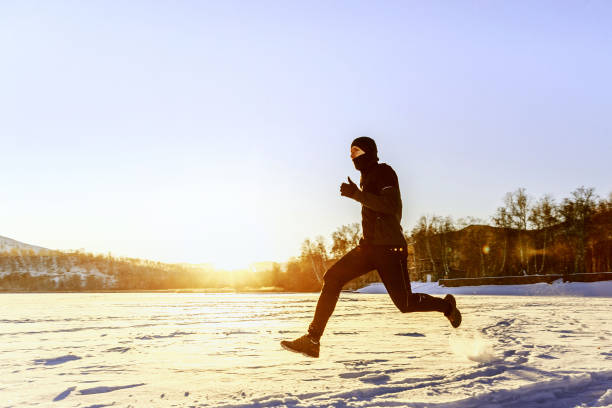 istock athlete runner running on snow in rays of sunset 903725030
