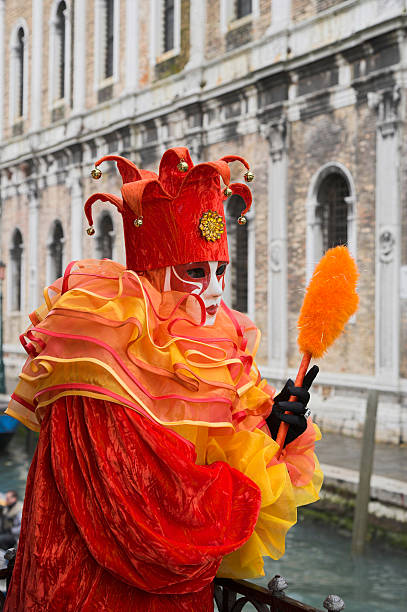 weibliche maske mit harlekin kostüm und historischen fassade in venedig - jester harlequin carnival venice italy stock-fotos und bilder